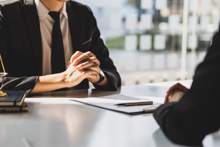Businessman hands clasped near legal documents