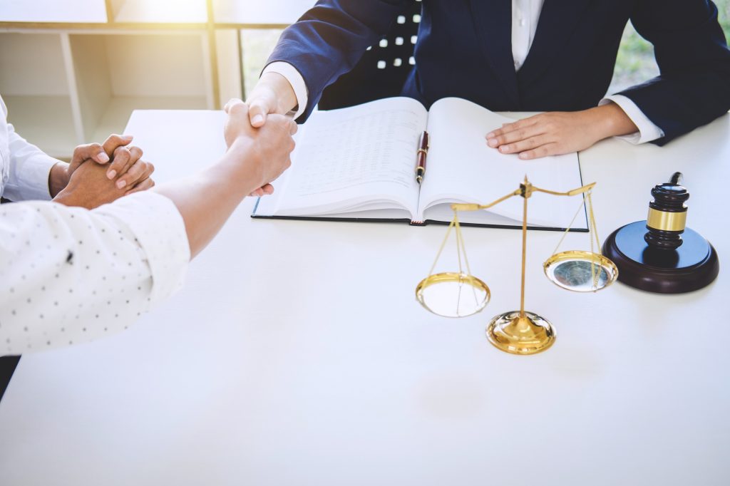 Lawyer and client handshake over legal papers
