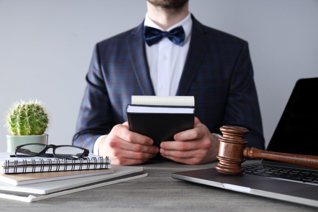 Man holding notebook with judge gavel desk