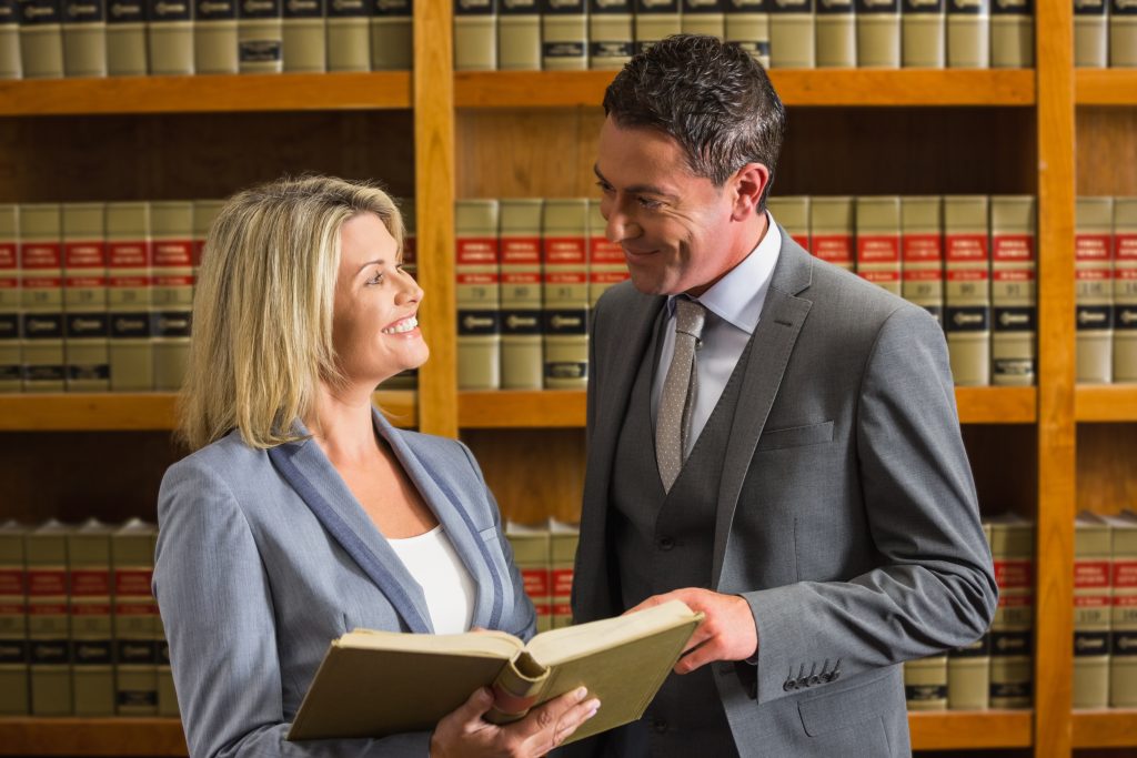 Lawyers reviewing legal book in library