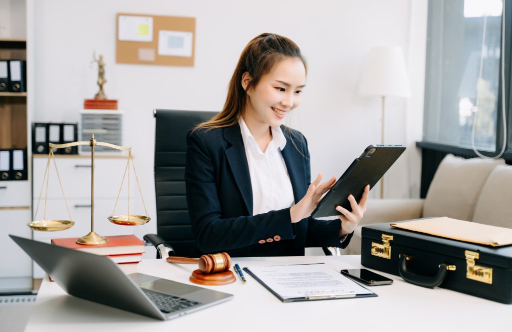 Female lawyer smiling using tablet in office